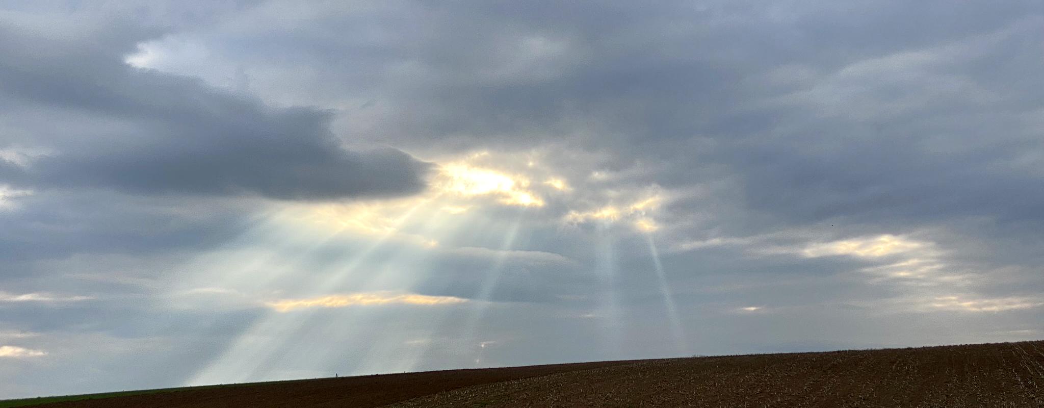 Wolkiger Himmel mit Sonnenstrahlen